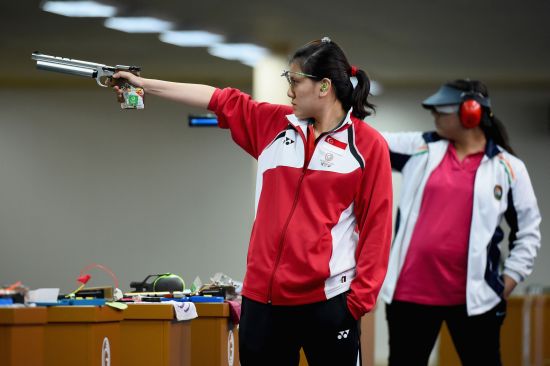 Shun Xie Tao of Singapore and Malaika Goel of India compete in the womens 10 meter air pistol 