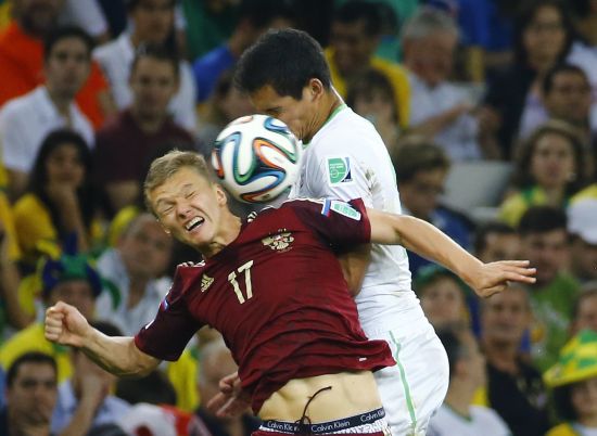 Russia's Oleg Shatov (L) jumps for the ball with Algeria's Aissa Mandi 