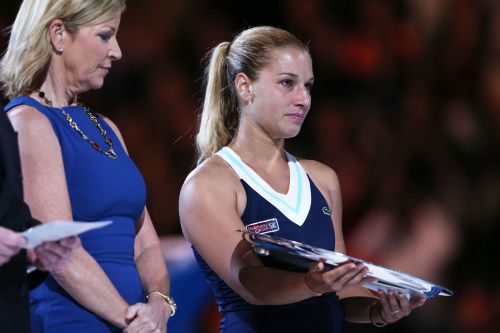 Dominika Cibulkova of Slovakia is presented with the runner up trophy by Chris Evert