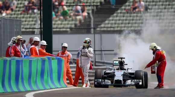 Lewis Hamilton of Great Britain and Mercedes GP walks away from his car after it caught fire 