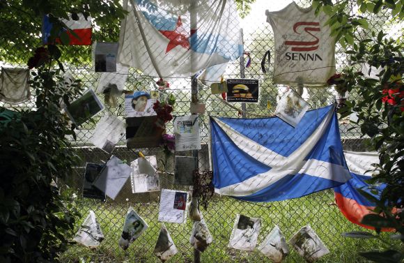 Handwritten notes and flags left by fans are pictured near the memorial statue of Brazilian Formula One driver Ayrton Senna at the race track in Imola 