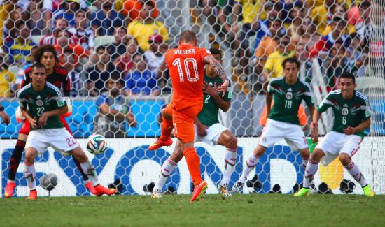 Wesley Sneijder of the Netherlands shoots and scores his team's first goal past Guillermo Ochoa of Mexico