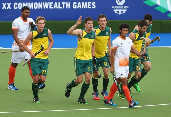 Simon Orchid (centre) of Australia celebrates after scoring a goal during the men's preliminaries match between India and Australia at the Glasgow National Hockey Centre