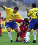 Brazil's Carlos Miguel (L) and Sonny Anderson (R) battle with Canada's Nick Dasovic.