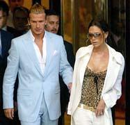 Real Madrid's new signing David Beckham (L) leaves his hotel with his wife Victoria in Madrid