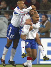 David Trezeguet (C) celebrates his goal with team mates Thierry Henry (R) and Olivier Dacourt during France's friendly against Germany