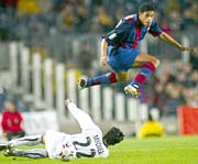 FC Barcelona's Dutch Michael Reiziger (R) jumps in front of Real Murcia's Michel Sanchez