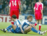 Porto's Edgaras Jankauskas (L) and Marco Ferreira sit on the pitch dejected after missing a goal