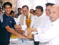 Rastogi is presented a trophy at the felicitation function