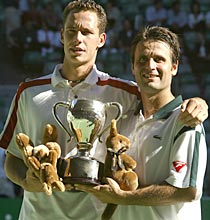 Michael Llodra (left) and Fabrice Santoro hold up the men's doubles trophy