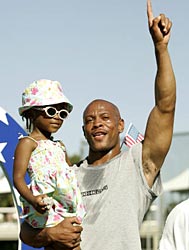 Greene, with his four-year-old daughter Ryan, after winning the 100m at the US trials.
