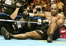 Mike Tyson sits on the canvas after being knocked out