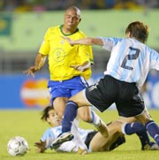Brazil's Ronaldo (C) drives through Argentina's Gabriel Heinze (2) and Facundo Quiroga in the second half of their World Cup qualifying match in Belo Horizonte