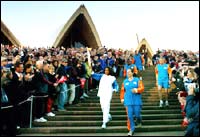 Cathy Freeman carries the Olympic torch down the steps of the Sydney Opera House 