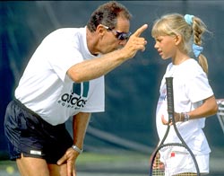 Tennis Coach Nick Bollettieri gives instructions to a young Anna Kournikova