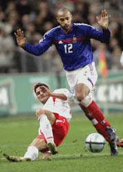 Thierry Henry is tackled by Michal Zewlakow of Poland