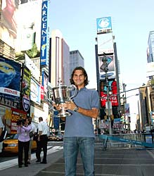 Roger Federer poses with his 2004 US Open trophy at Times Square in New York