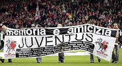 Liverpool and Juventus fans carry a banner stating the name of those killed in the Heysel Stadium disaster before their Champions League quarter-final first leg match