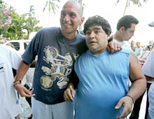 Argentine soccer legend Diego Maradona (R) poses with a fan in Cartagena.