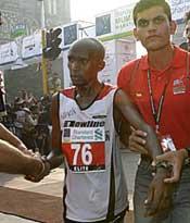 Julius Sugut is taken away for his dope test after crossing the finish line