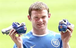 Wayne Rooney poses for photographs with his new World Cup football boots