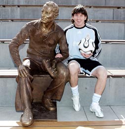 Lionel Messi sits next to a statue of Adidas founder Adi Dassler at the World of Sports Stadium in Herzogenaurach, Germany