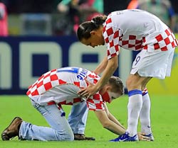A pitch invader kisses the boots of Croatian striker Dado Prso