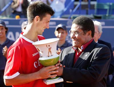 Novak Djokovic (left) receives the trophy from Eusebio
