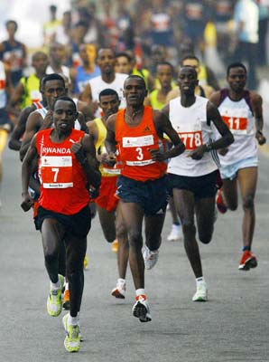 Rwanda's Diudone Disi (L) leads the pack at the start of the Delhi Half Marathon