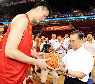 China's NBA star Yao Ming (left) presents an autographed ball to Chinese Premier Wen Jiabao in Beijing