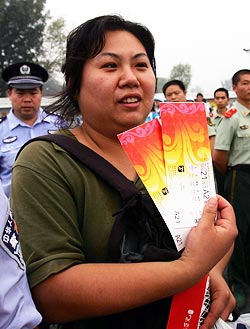 A Chinese woman displays the tickets she bought from a ticket booth after queuing for many hours in Beijing, on Friday