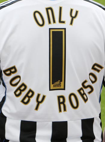 A man is seen wearing a Newcastle United shirt as a tribute to former manager Robson at the club's stadium in Newcastle.