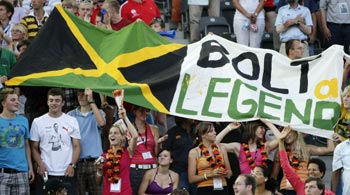 Supporters of Usain Bolt of Jamaica hold a flag during the world athletics championships at the Olympic stadium in Berlin