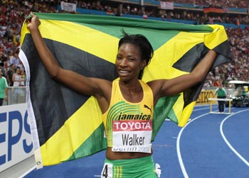 Melanie Walker of Jamaica holds up her national flag as she celebrates winning the women's 400 metres hurdles