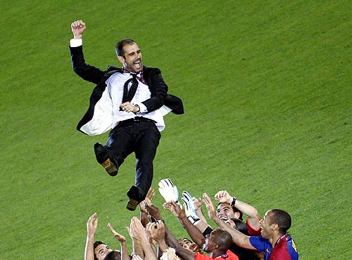 Barcelona's coach Pep Guardiola is chaired by his players