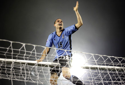 Uruguay's Perez celebrate atop the goal post at the end of their World Cup 2010 qualifying soccer match against Costa Rica