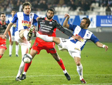 Lisandro Lopez (centre) of Olympique Lyon challenges Sandy Paillot (left) and David Sauget of Grenoble during their French Ligue 1 tie on Saturday