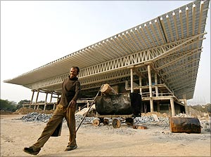 A labourer walks at the Thyagaraja Sports Complex, one of the venues for the Commonwealth Games 2010