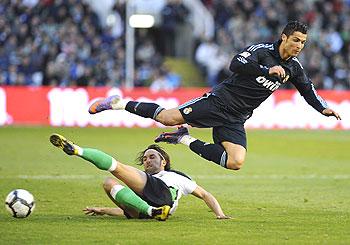 Racing Santander's Oscar Serrano Rodriguez (left) challenges Real Madrid's Cristiano Ronaldo during their La Liga match on Sunday