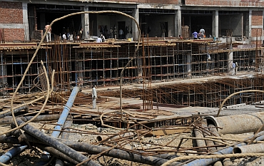 Labourers work at the construction site of the Shivaji stadium, which will be used as a training venue for hockey, during the 2010 Commonwealth Games