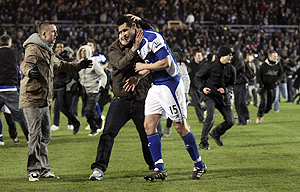 Supporters run onto the pitch to congratulate Birmingham City's Scott Dann after winning their League Cup against Aston Villa on Wednesday