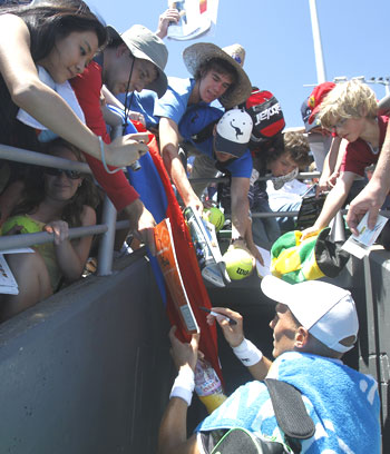 Russia's Nikolay Davydenko obliges fans by signing autographs after defeating Dieter Kindlmann