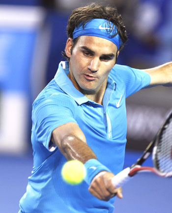 Roger Federer returns against Lleyton Hewitt