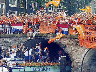 Fans cheer as they welcome the Dutch team back home during a canal parade in Amsterdam