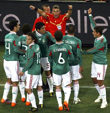 Mexico's players appeal to referee Rosetti for Argentina's goal to be disallowed during last month's World Cup