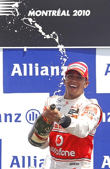Lewis Hamilton pops the bubbly on the podium after winniing the Canadian GP