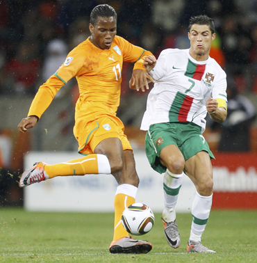 Ivory Coast's Didier Drogba fights for the ball with Portugal's Cristiano Ronaldo during their 2010 World Cup