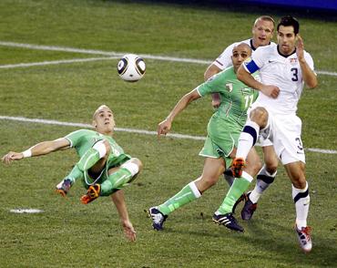 Algeria's Hassan Yebda (L) kicks the ball as United States' Carlos Bocanegra defends during a 2010 World Cup Group C soccer match at Loftus Versfeld stadium in Pretoria