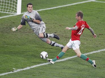 Portugal's Raul Meireles sits on the pitch after his effort goes off target as Brazil's goalkeeper Julio Cesar lies injured at Moses Mabhida stadium in Durban