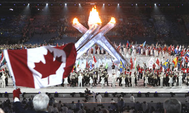 Gordon Campbell the Premier of British Columbia waves a Canadian flag during the closing ceremony